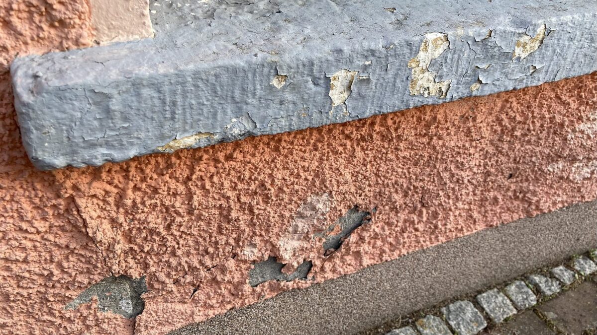 Lachsfarben überstrichener Spritzputz (wohl in der DDR-Zeit aufgebracht), im Sockelbereich ergänzt mit moderne