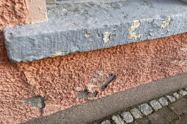 Lachsfarben überstrichener Spritzputz (wohl in der DDR-Zeit aufgebracht), im Sockelbereich ergänzt mit moderne